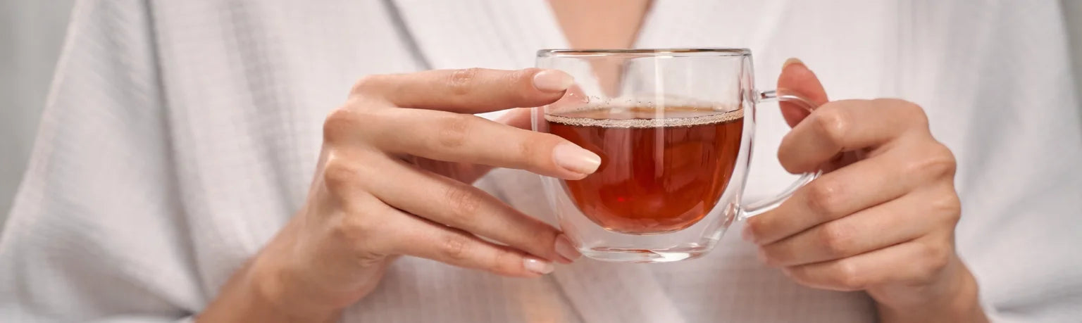 Premium tea collection cover featuring a single glass cup of tea in a calm, minimalist setting with warm, refined tones
